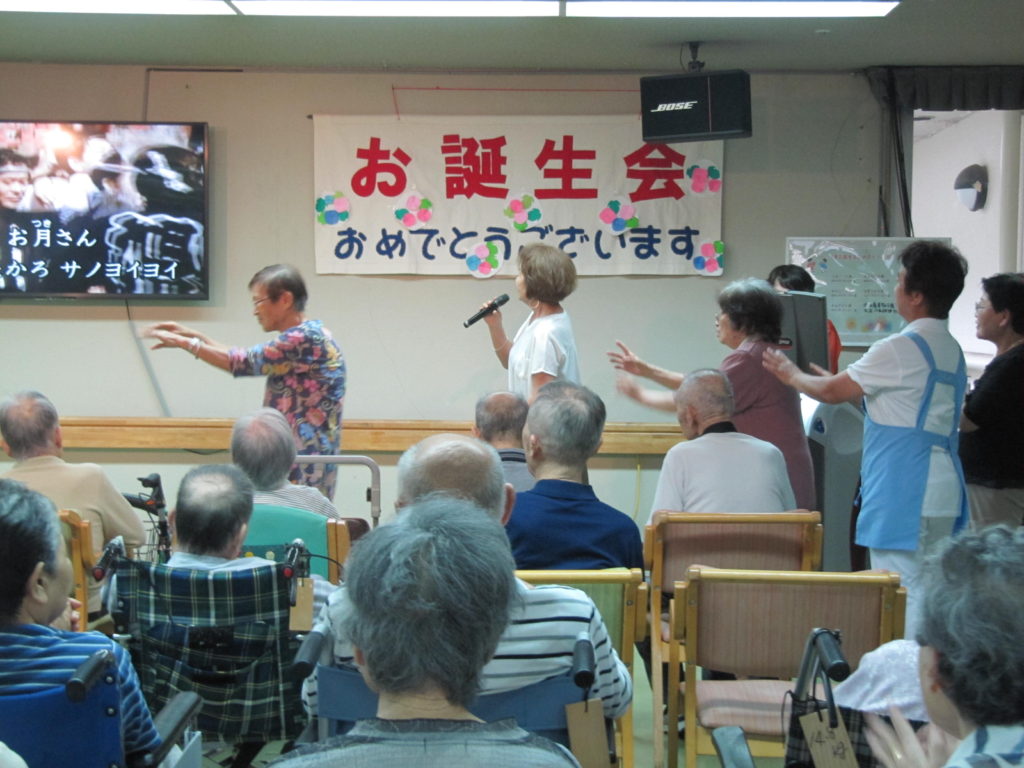 特別養護老人ホーム山彦苑にて、地域の方がスタッフが一緒に歌い踊る様子