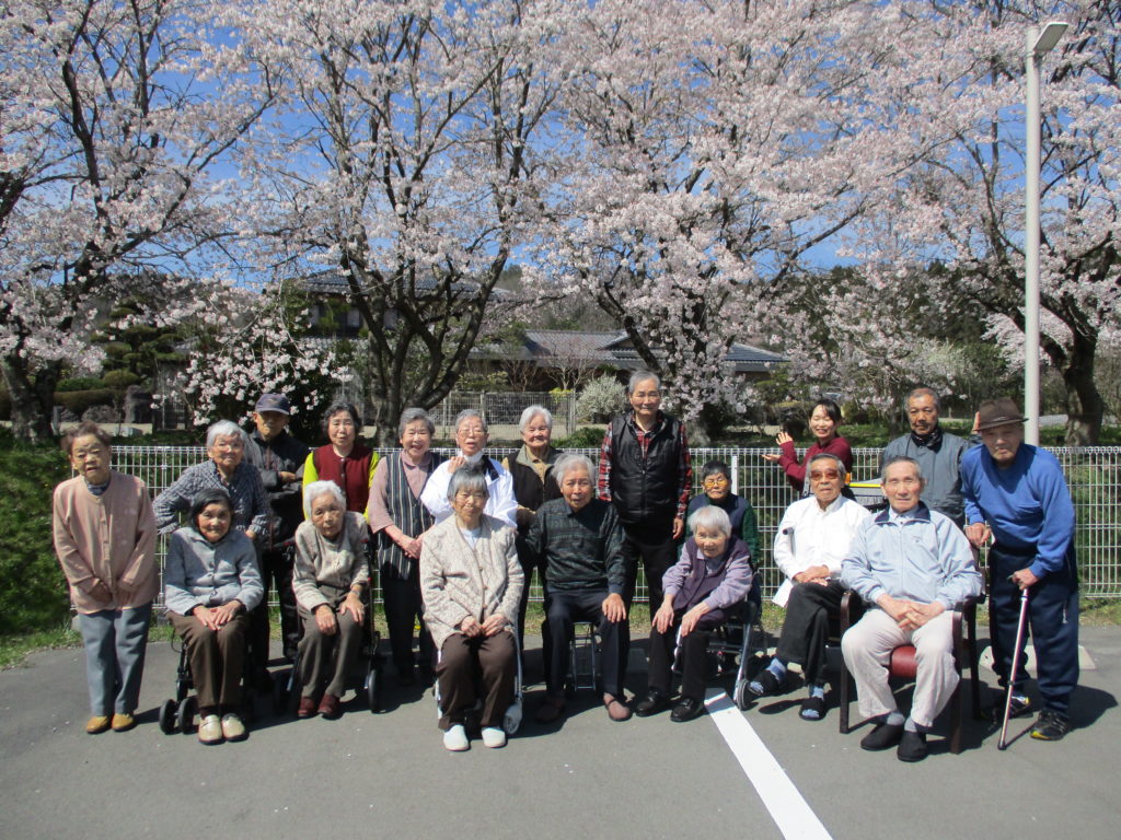 サポートハウス木蘭にて、桜と一緒に撮影会をする利用者たち